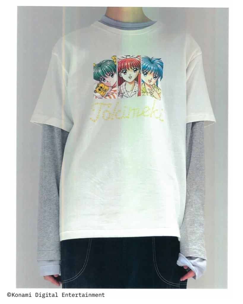 White layered Tee over a gray long-sleeve shirt featuring three colorful Tokimeki Memorial character portraits and a yellow logo across the chest