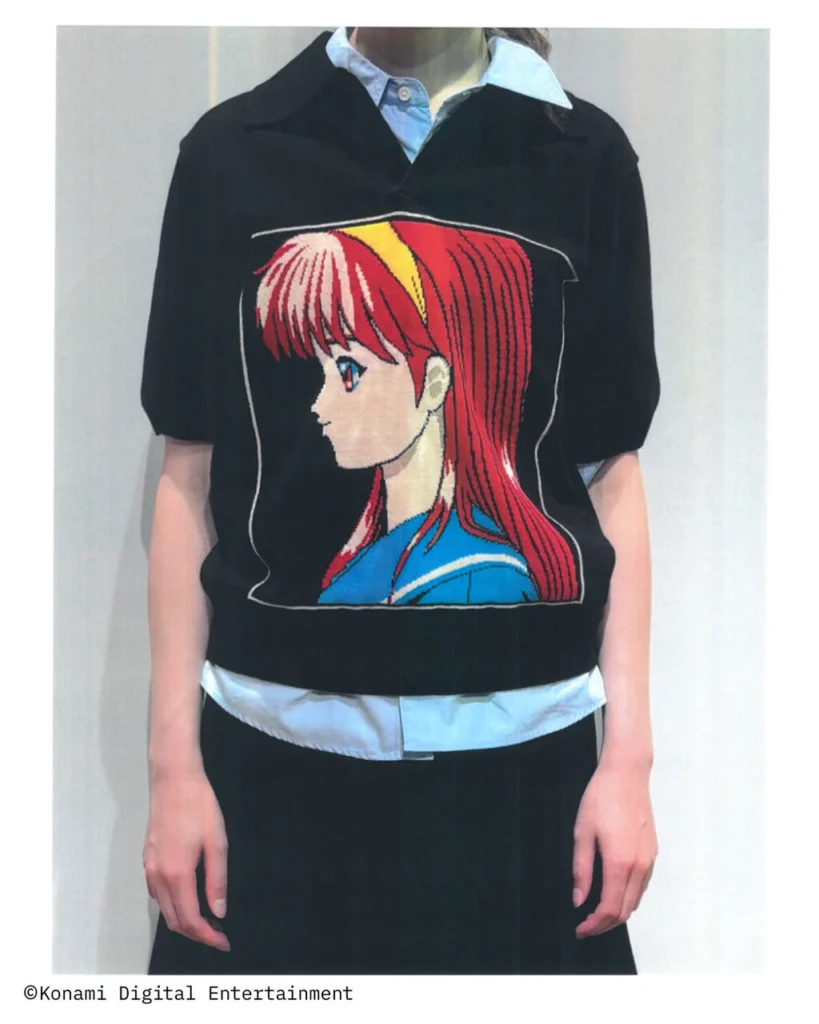 : Black short-sleeve knit polo with a large embroidered side-profile anime character graphic, styled over a light blue collared shirt