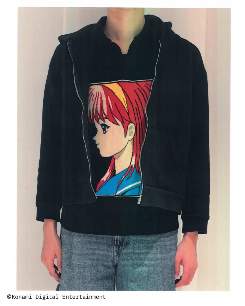 Black zip hoodie layered over a black knit top featuring a large embroidered anime character portrait, paired with light blue denim jean