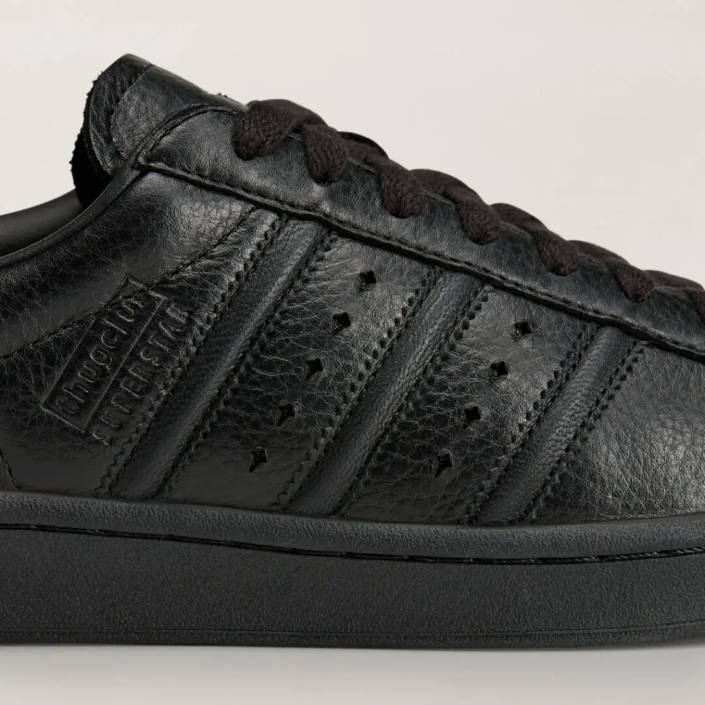Close-up of the adidas Originals by Taqwa Bint Ali Superstar highlighting its textured black leather upper, embossed branding, and tonal Three Stripe