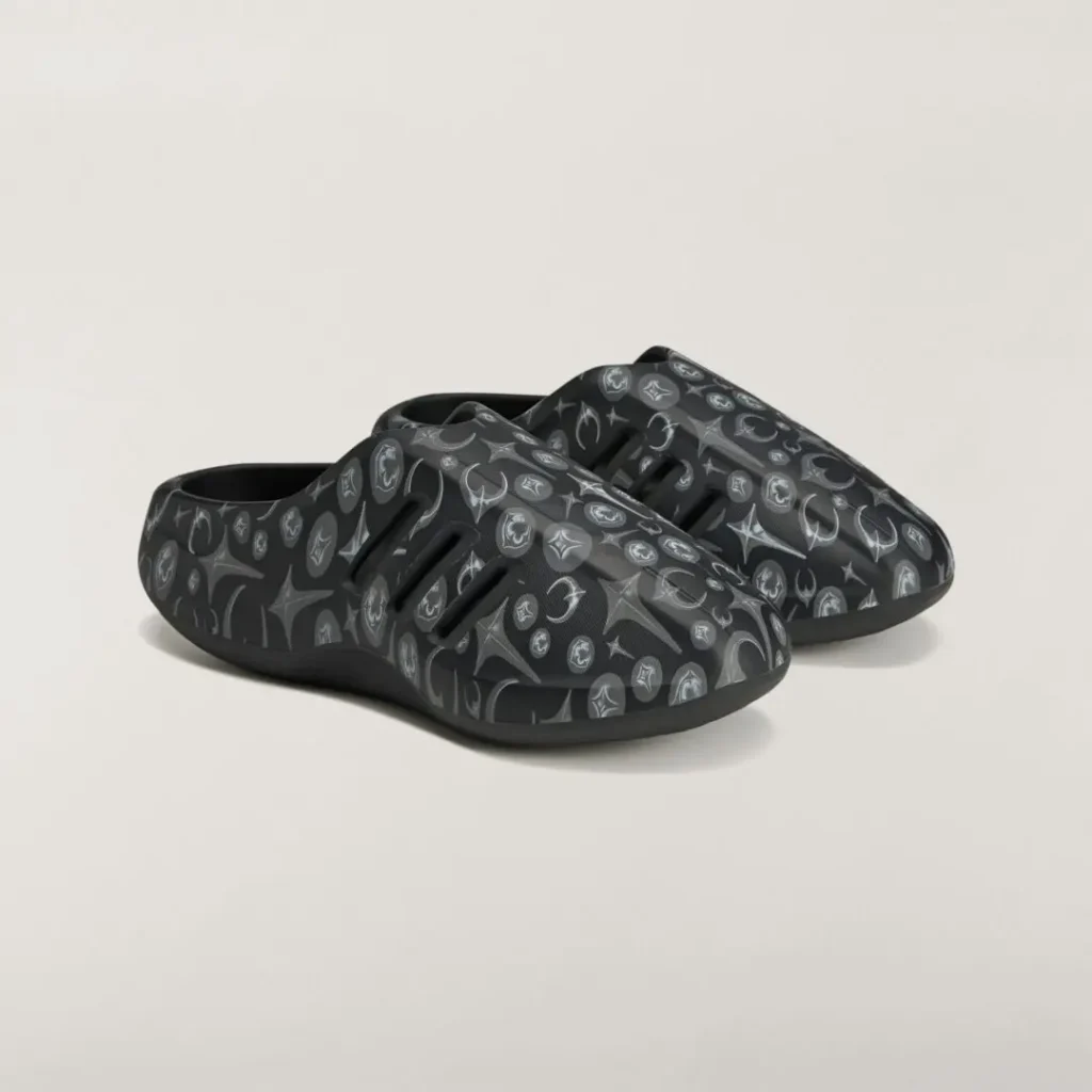 Three-quarter view of the adidas Originals by Taqwa Bint Ali Adistar Cushion Mule showcasing its all-over monochrome graphic print