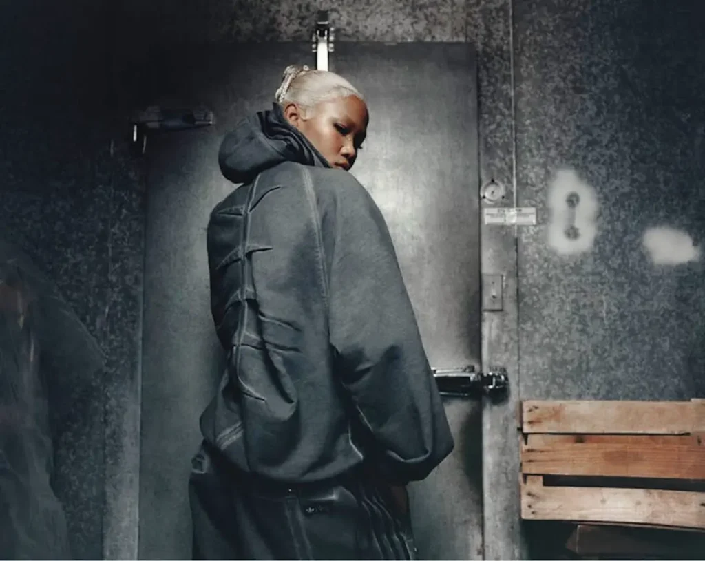 Rear campaign portrait of a model wearing a charcoal adidas Originals by Taqwa Bint Ali hoodie showcasing the sculpted stitched back panel