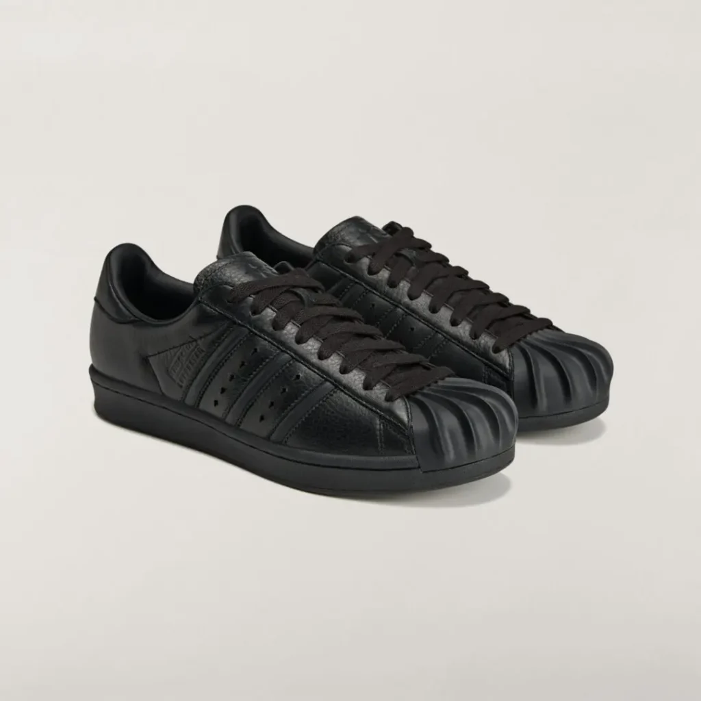 Three-quarter view of the black adidas Originals by Taqwa Bint Ali Superstar showcasing its premium leather construction and sculpted shell toe
