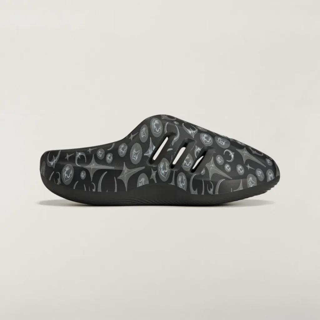 Side profile of the adidas Originals by Taqwa Bint Ali Adistar Cushion Mule featuring an all-over monochrome graphic print and ventilated slip-on design