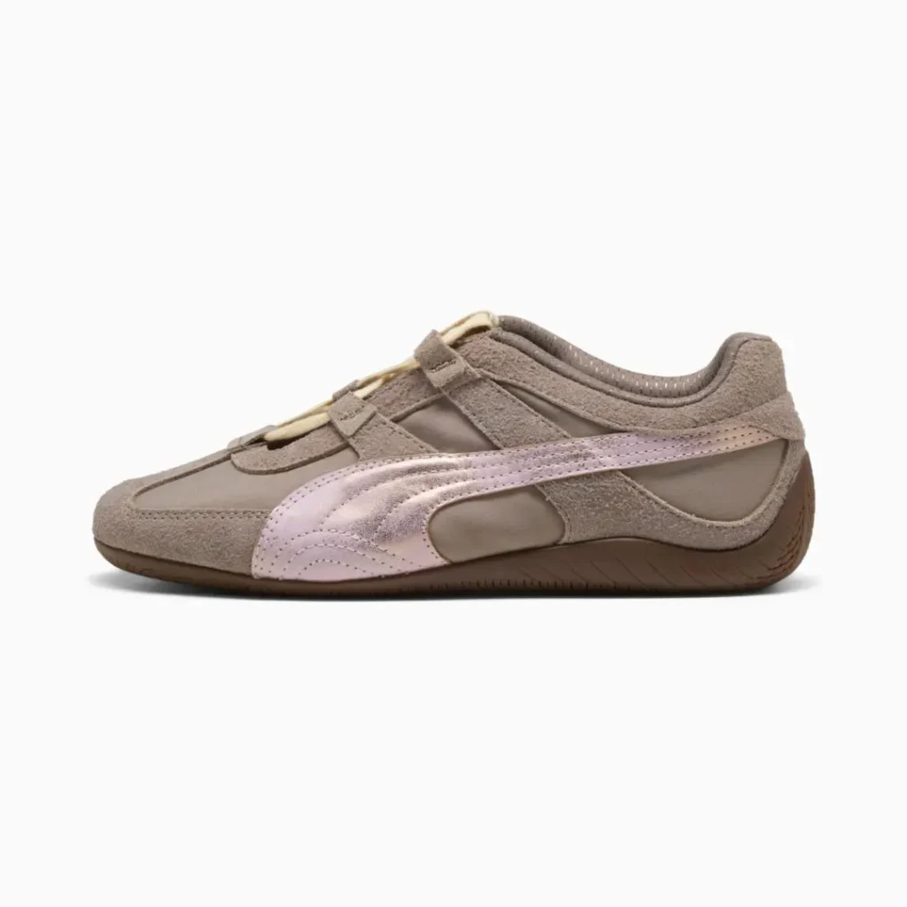 Side profile of the Puma shoe highlighting the taupe suede overlays, matte textile upper, pale pink Formstrip, cutout construction, and slim brown sole