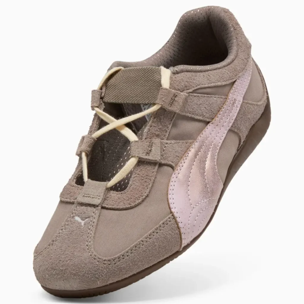 Angled front view emphasizing the T-strap-inspired upper, elastic instep band, cream lace system, taupe suede mudguard, and metallic pale pink Formstrip