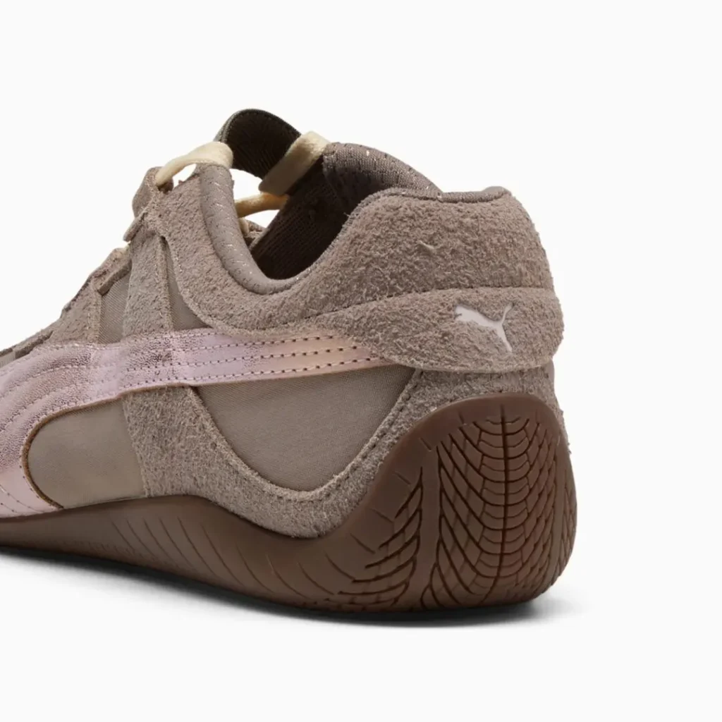 Rear three-quarter close-up showcasing the textured suede heel, embroidered Puma logo, pale pink Formstrip wrapping the heel, and sculpted brown rubber outsole with patterned traction