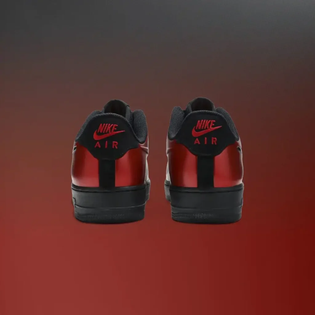 Rear view of a pair of metallic red Nike Air Force 1 Low sneakers featuring black heel tabs with red Nike Air brand