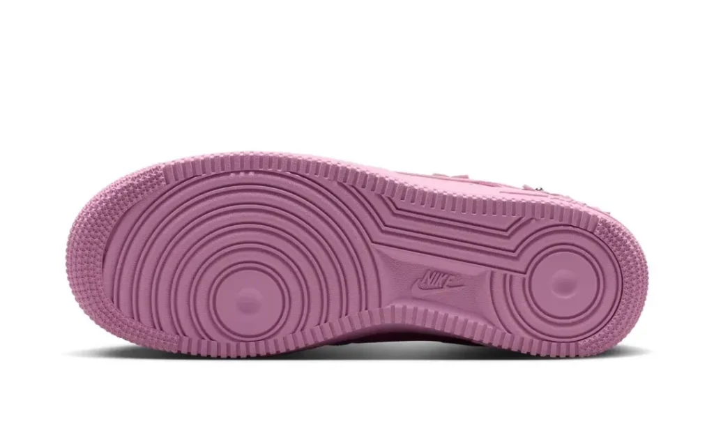 Bottom view of the pastel pink Nike Air Force 1 showing the classic concentric-circle rubber outsole pattern