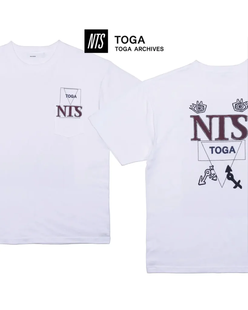 White and black pocket Tee with NTS and TOGA graphics on the chest pocket and large show logo artwork on the back
