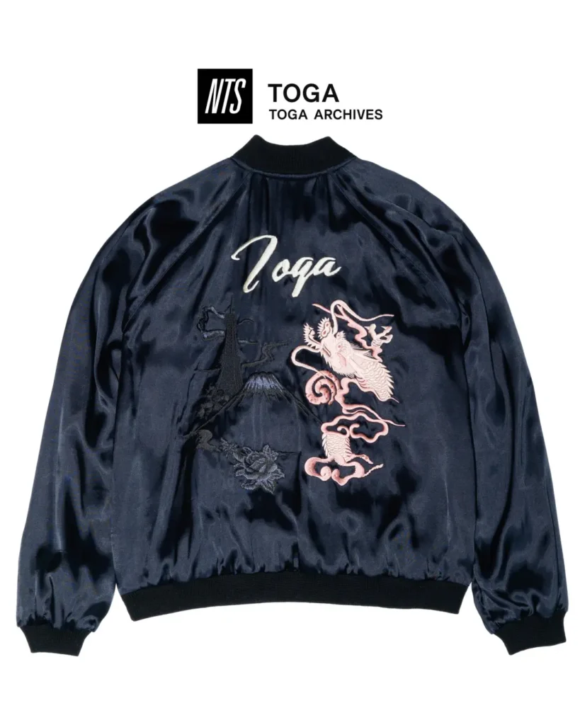 NTS x TOGA Archives satin souvenir jacket (dragon): Navy satin souvenir jacket embroidered with a pink dragon, Mount Fuji-inspired landscape, floral accents, and oversized TOGA script across the back