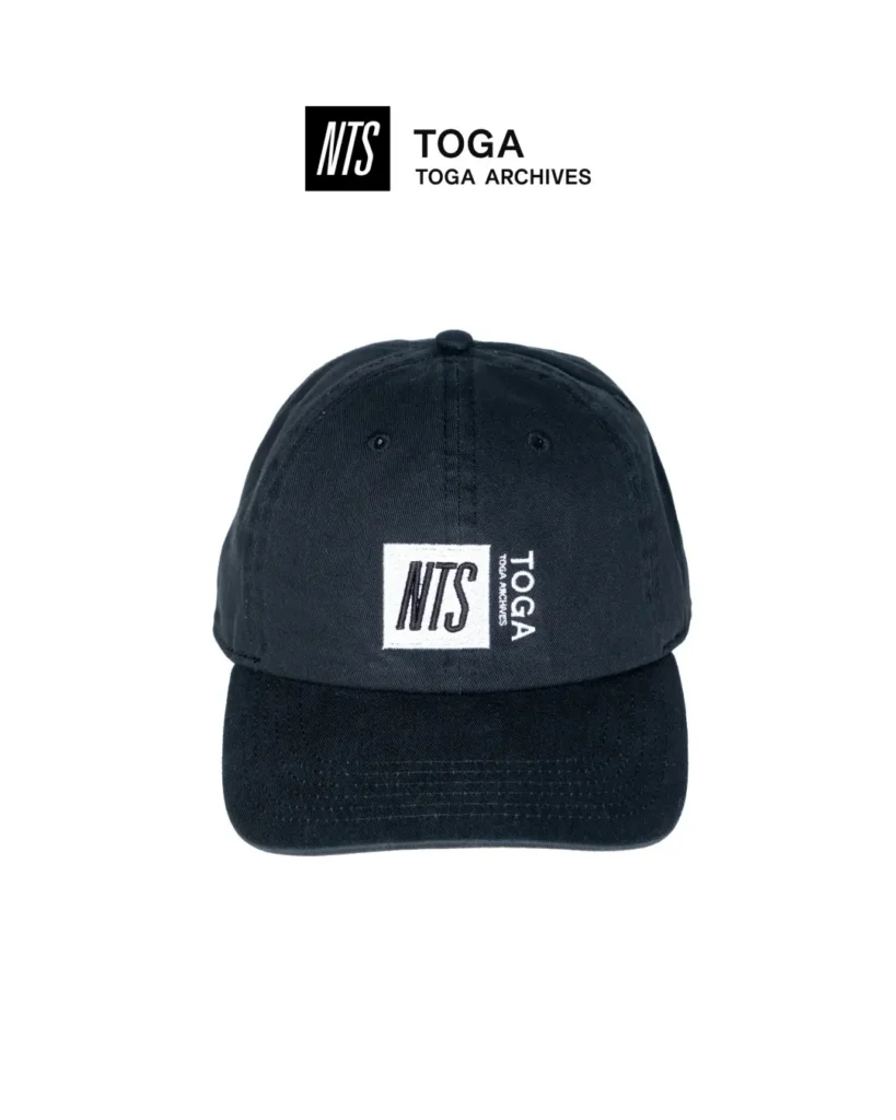 Black six-panel baseball cap with embroidered NTS patch and TOGA Archives logo on the front