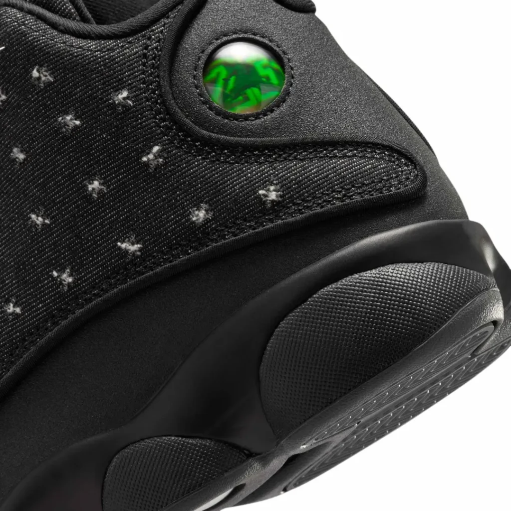 Interior tongue label of the Air Jordan 13 "Wings" featuring a gold Jumpman graphic above the "WINGS" wordmark against a black woven tag