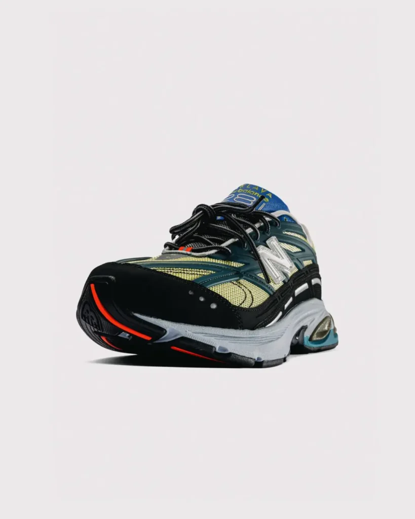 Low-angle front three-quarter view of the New Balance x Baklava 281, highlighting the aggressive toe shape, layered upper, oversized midsole, and bright orange traction detail