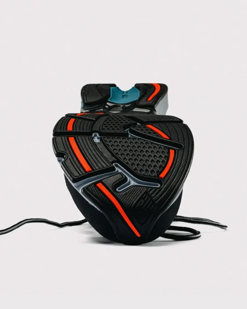 Outsole view of the New Balance x Baklava 281, displaying black rubber tread with segmented orange traction inserts and a blue midfoot stable