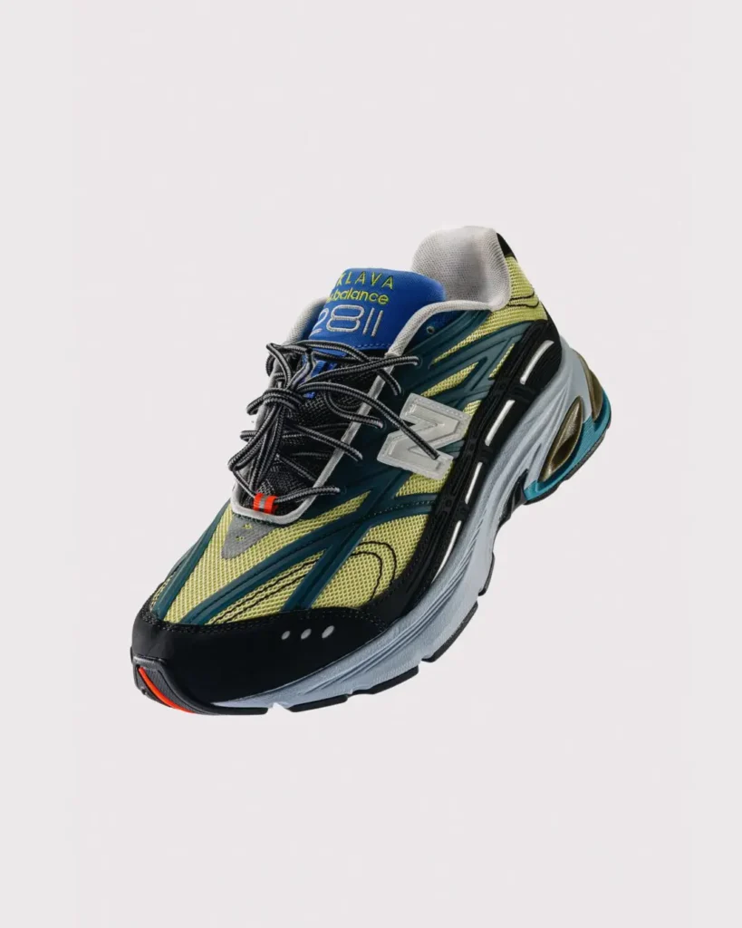 Floating three-quarter product shot of the New Balance x Baklava 281, showcasing translucent branding, layered mesh construction, oversized cushioning, and multi-color tech design