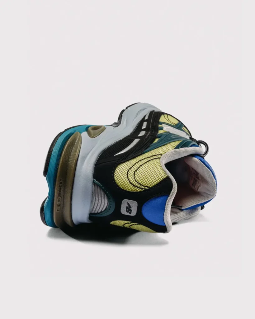 Rear angled view of the New Balance x Baklava 281, highlighting the blue heel tab, mesh heel panels, exposed ABZORB cushioning, and black molded heel support