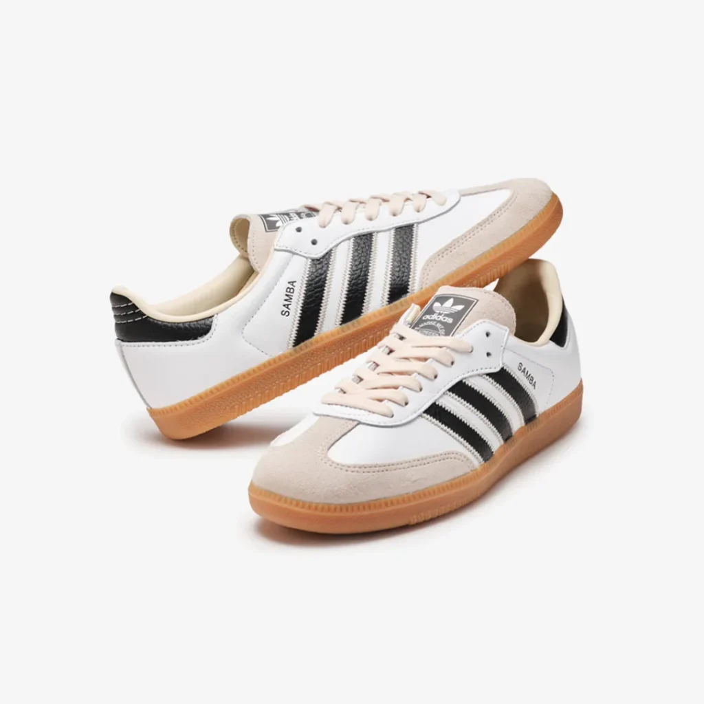 Pair of white adidas Samba shoe displayed from multiple angles, highlighting premium leather panels, suede mudguard, and gum outsole