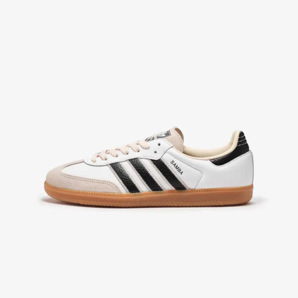 Side profile of the white adidas Samba featuring black Three Stripes, cream suede toe cap, and classic gum sole