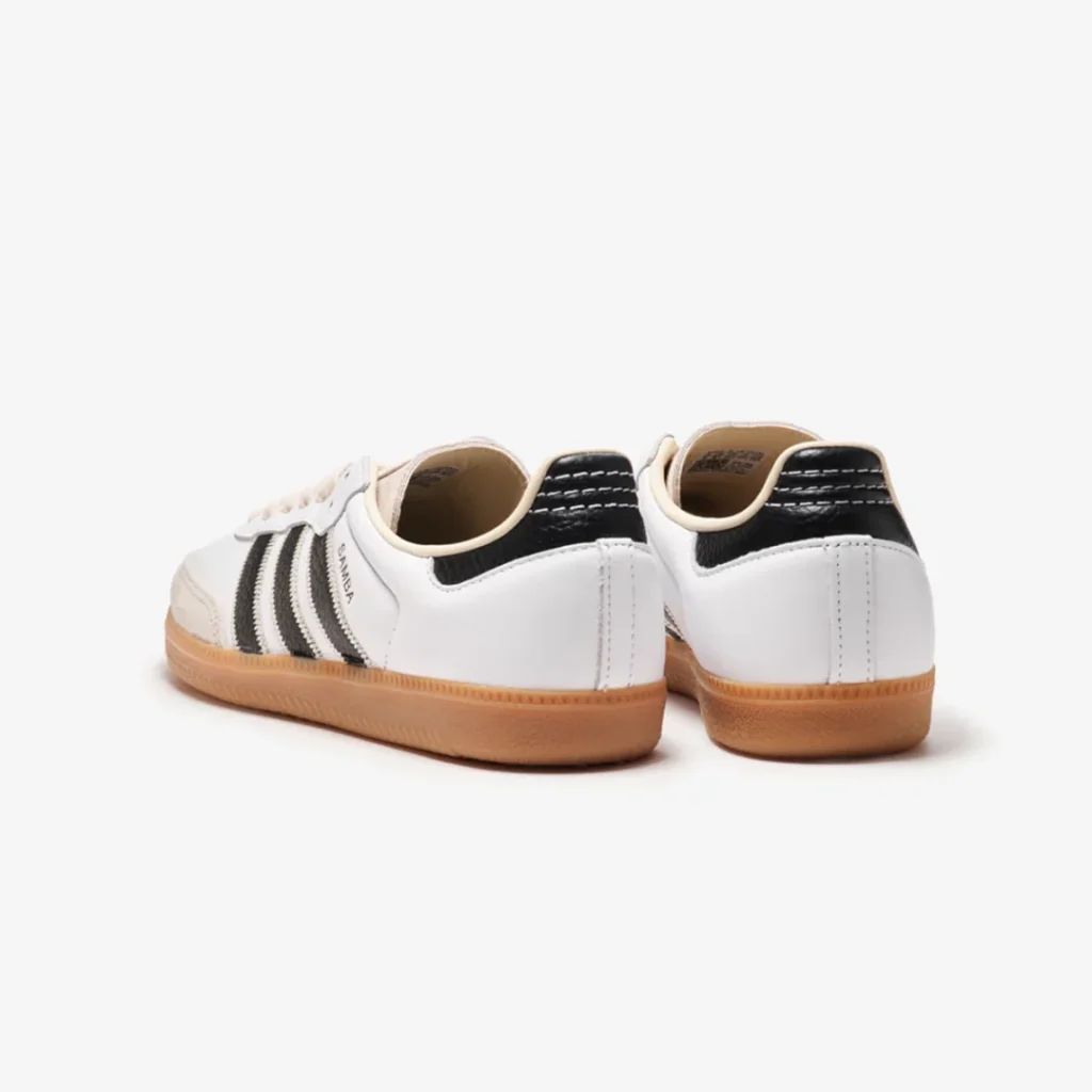 Rear three-quarter view of the white adidas Samba showing black leather heel tab, cream lining, and gum sole