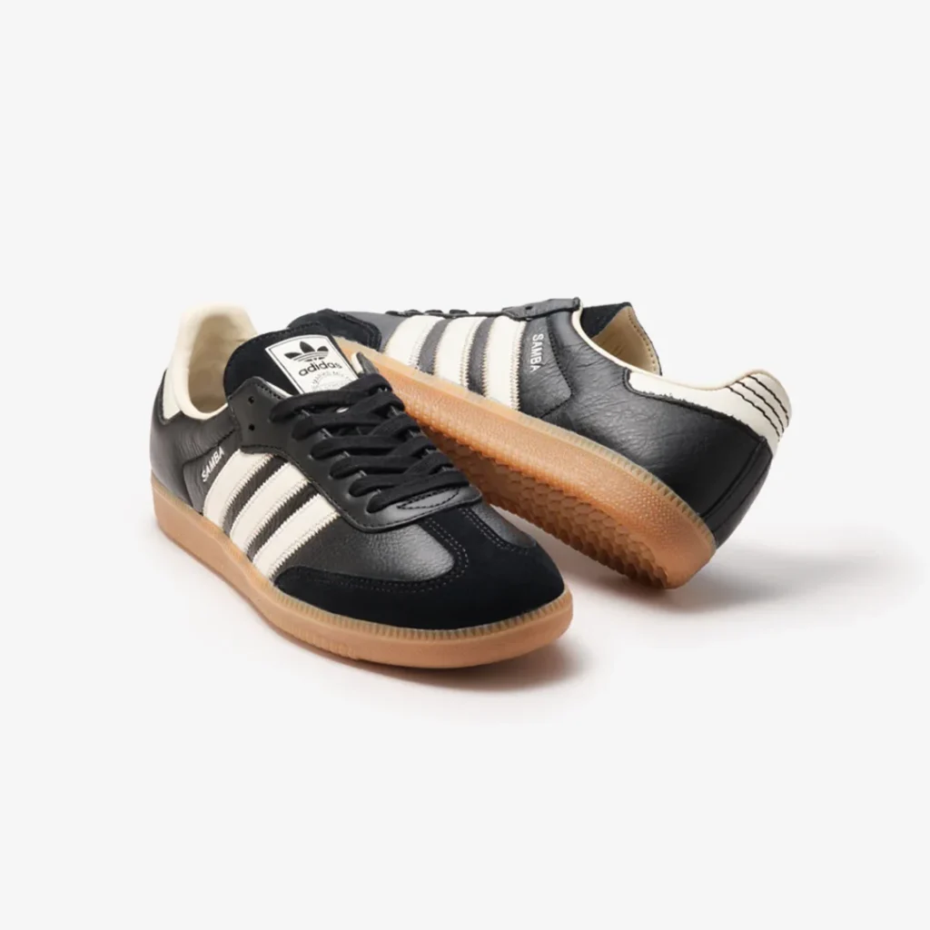Pair of black adidas Samba shoe displayed from multiple angles, emphasizing textured leather, suede toe, and classic gum outsole