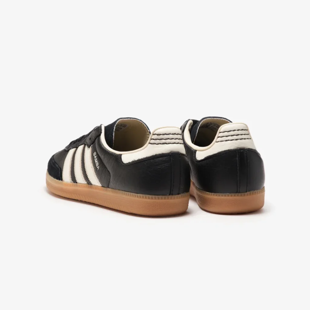 Rear three-quarter view of the black adidas Samba with off-white heel tab, stitched detailing, and gum sole