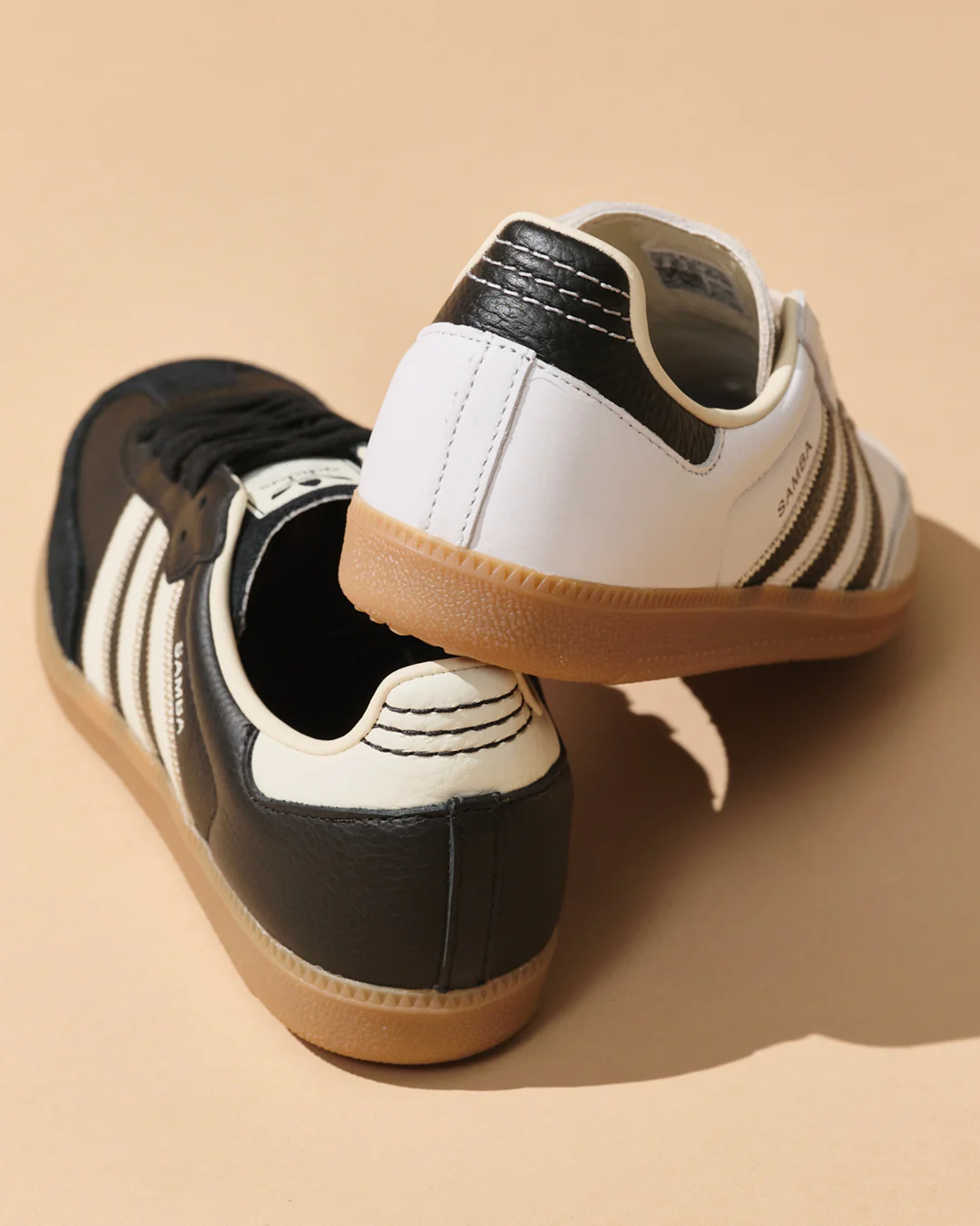 Rear view of black and white adidas Samba sneakers highlighting premium leather heel tabs, contrast stitching, and classic gum rubber soles.