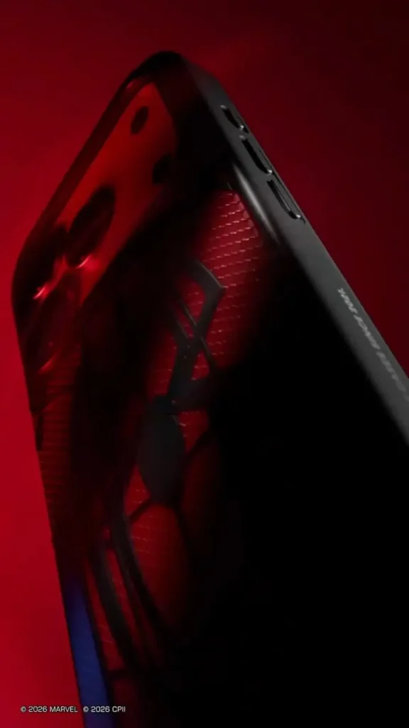 Dramatic side profile of the Spider-Man phone case under deep red lighting, emphasizing the raised black spider emblem, textured web surface, slim black bumper edges, side buttons, and premium layered construction