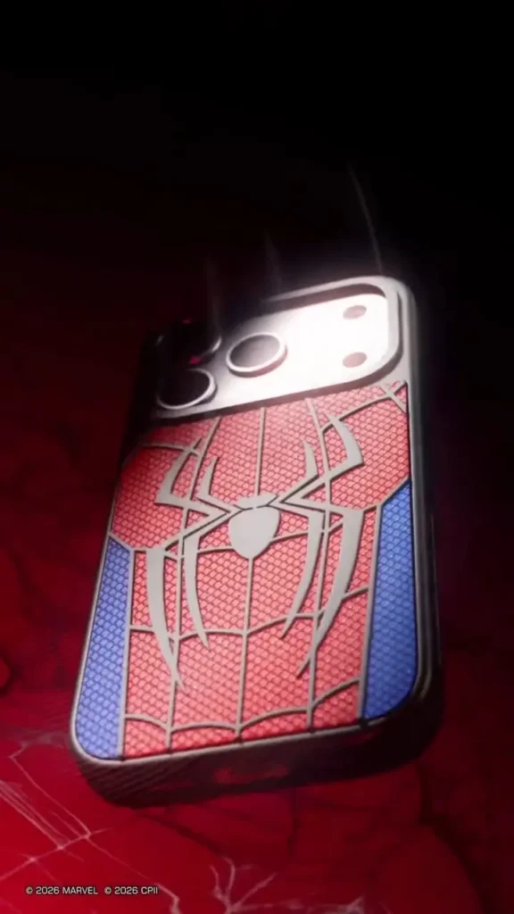Hero product shot of the Spider-Man CASETiFY phone case standing upright on a red-lit surface, featuring a silver spider emblem across a textured red web design with blue side panels, black bumper edges, and bright reflections around the camera cutout