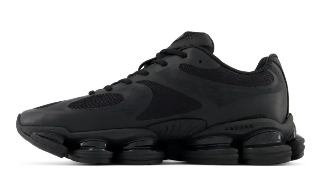 Lateral side profile of the all-black New Balance ABZORB 2000, highlighting the sculpted mesh and synthetic upper, oversized segmented ABZORB SBS cushioning pods, textured heel support, and monochromatic finish on a white background