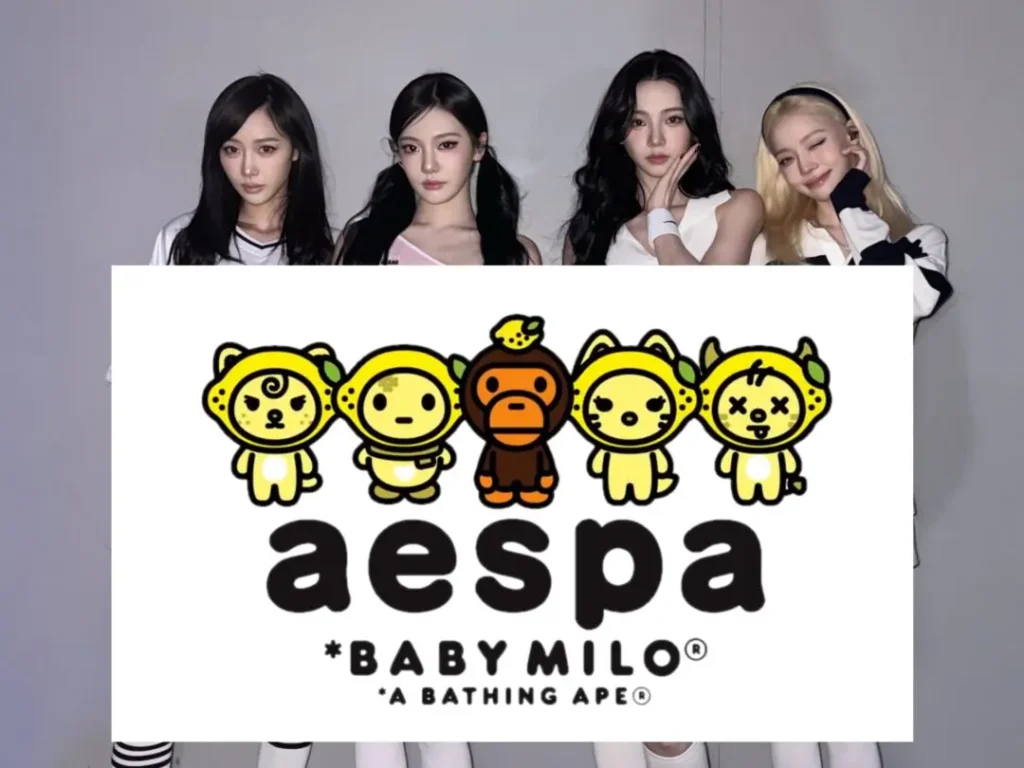 Four members of aespa stand behind a large display board featuring the BABY MILO collaboration artwork, posing against a clean studio backdrop