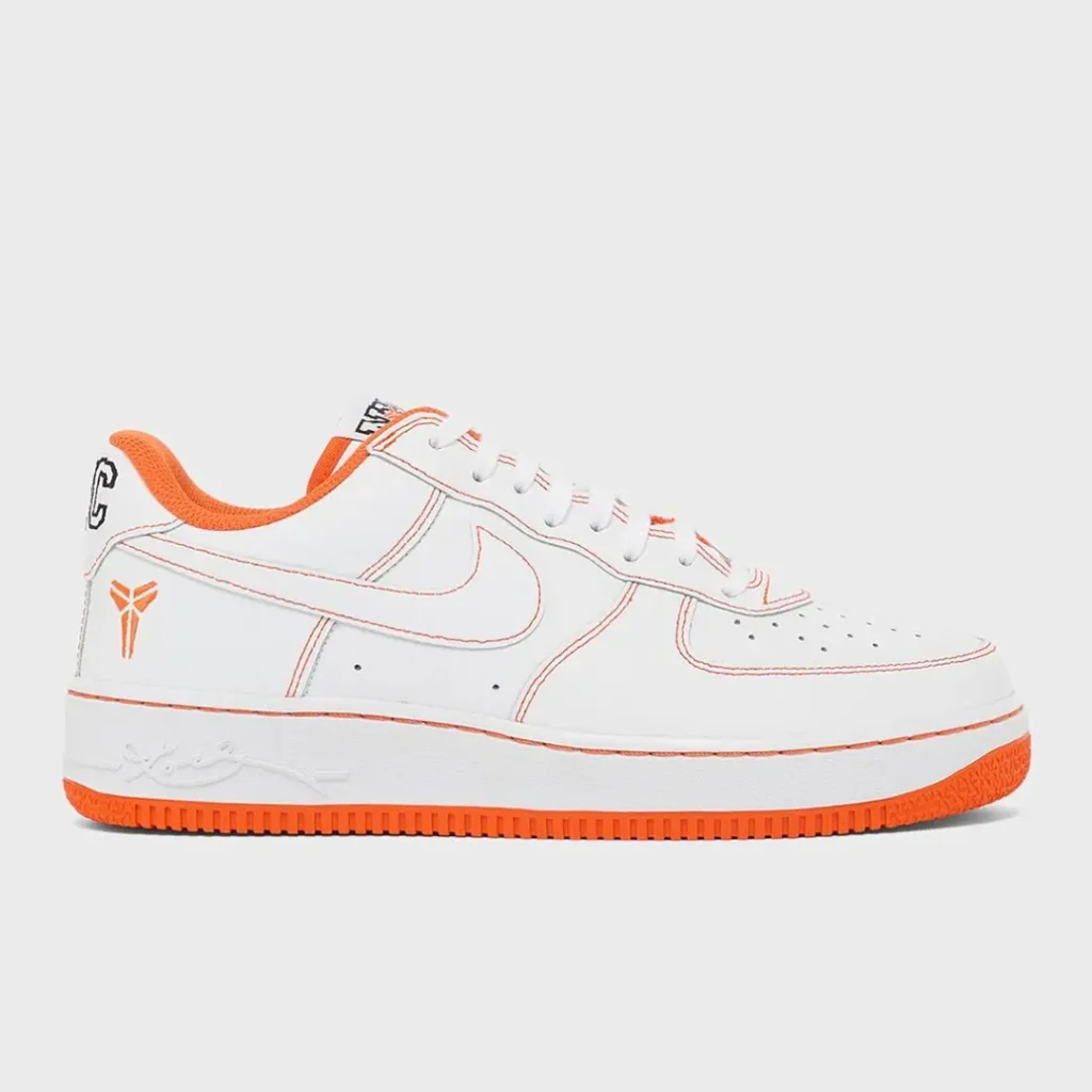 Medial side profile of the white and orange Nike Air Force 1 Low featuring clean leather panels, orange stitching, orange lining, embossed signature on the midsole, and solid orange outsole