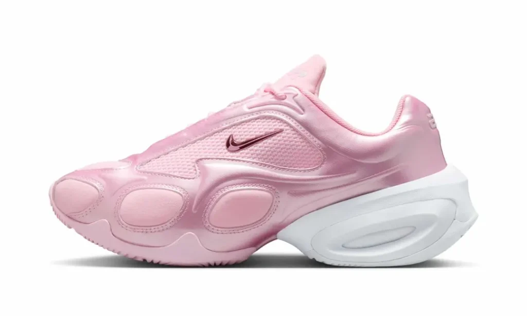 Metallic pastel pink Nike Air Max Muse shown in profile with sculpted synthetic overlays, mesh inserts, a miniature metallic Swoosh, and oversized white heel cushion