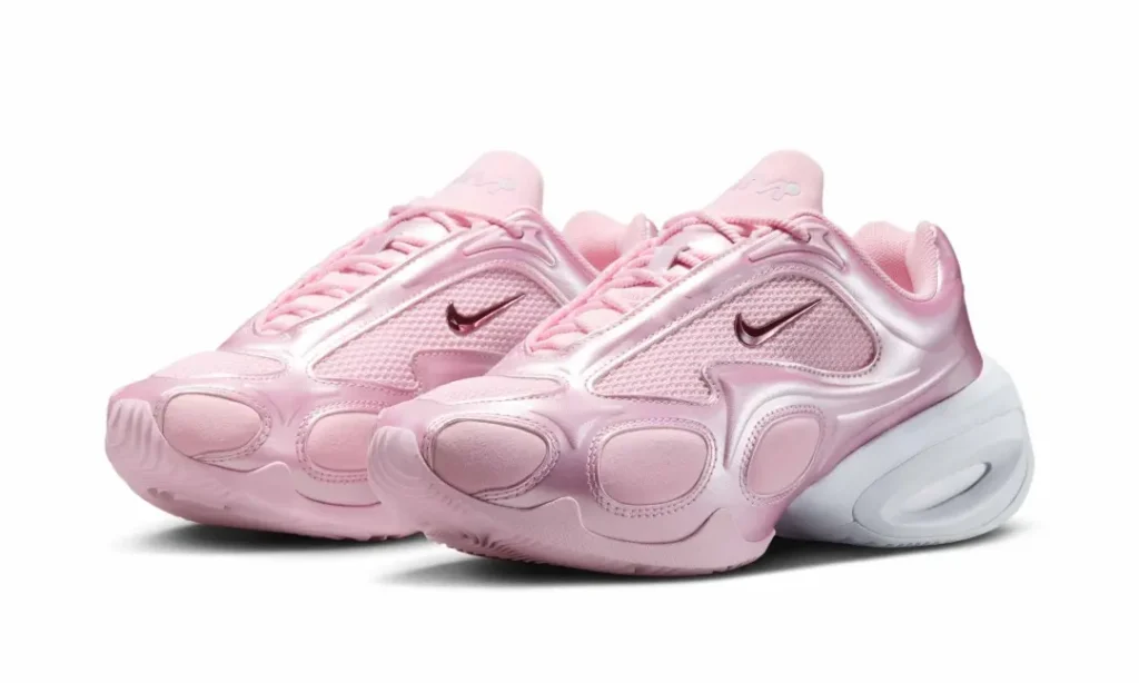 Angled three-quarter view of the metallic pastel pink Nike Air Max Muse pair showcasing sculpted overlays, breathable mesh panels, miniature metallic Swooshes, and oversized white heel cushion