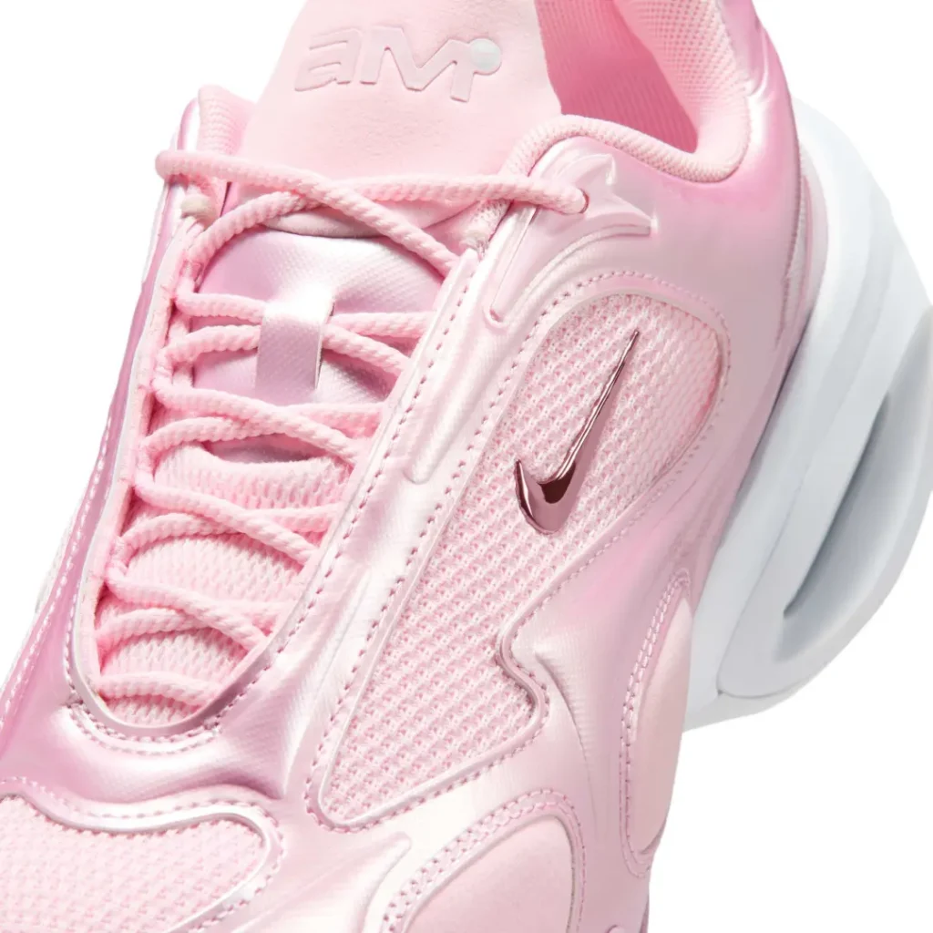 Close-up of the Air Max Muse upper featuring metallic pink overlays, open mesh side panel, rope laces, embossed tongue brand, and a metallic mini Swoosh