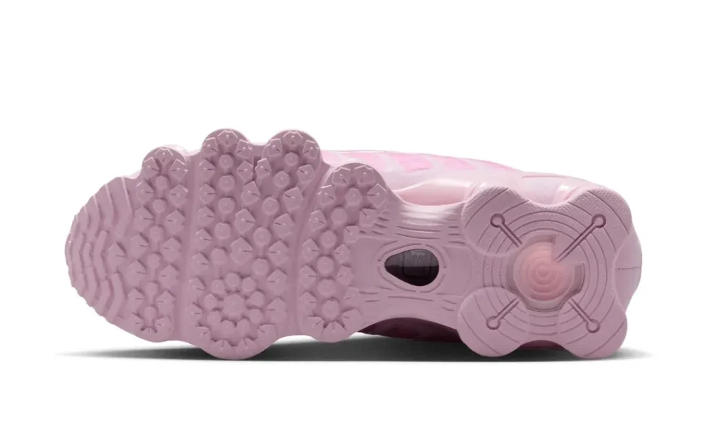 Bottom view of the pink Nike Shox TL highlighting the sculpted rubber outsole with multi-directional traction pattern, exposed midfoot window, and Shox platform