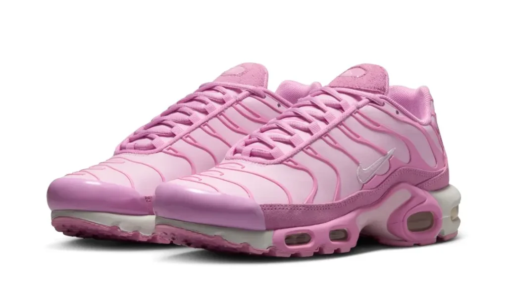 Angled three-quarter view of the pink Air Max Plus pair emphasizing the gradient-inspired upper, visible Air cushion, and sculpted midsole