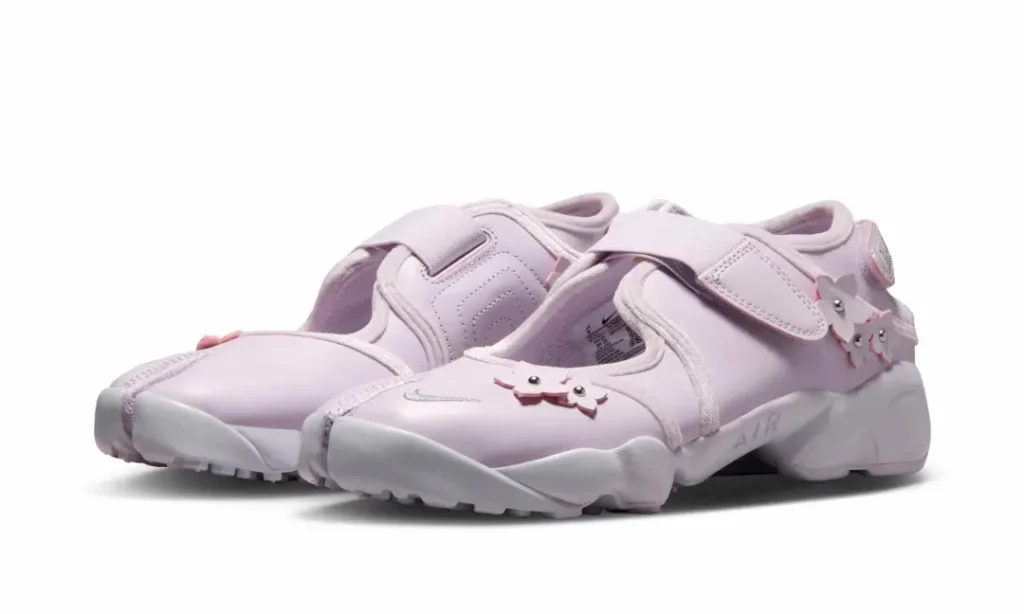 Angled three-quarter view of the pastel pink Air Rift pair emphasize the split-toe sil, decorative floral accents, and lightweight profile