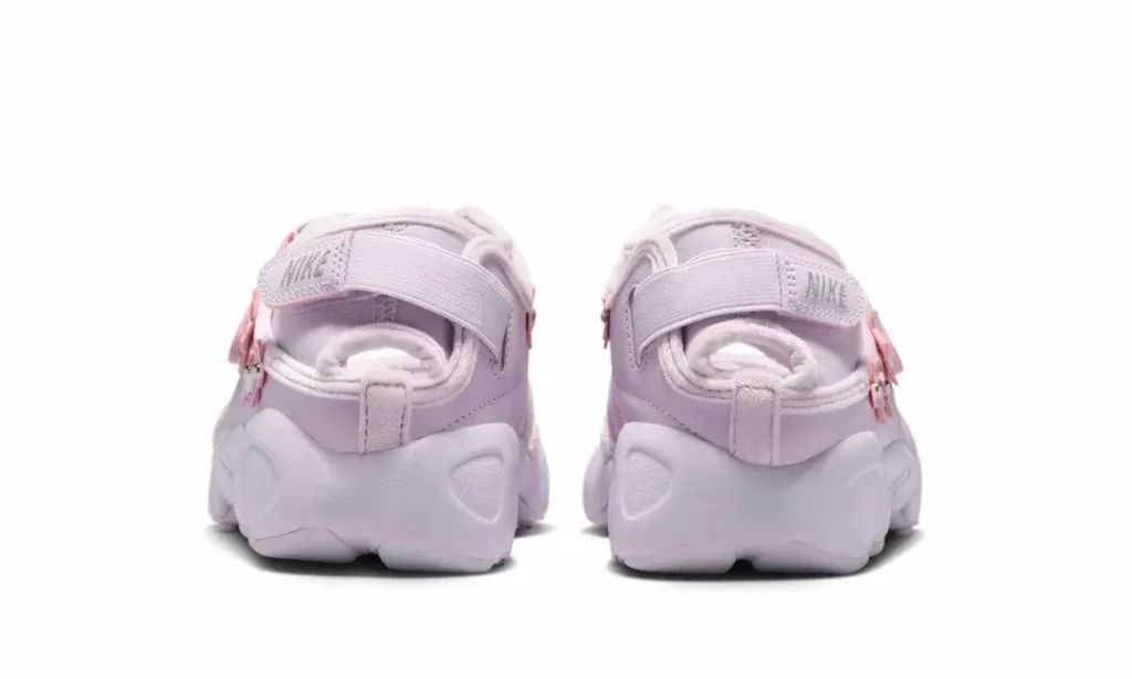 Close-up of the Air Rift upper featuring the hook-and-loop strap, soft suede trim, floral appliqués with metallic bead centers, and layered construction