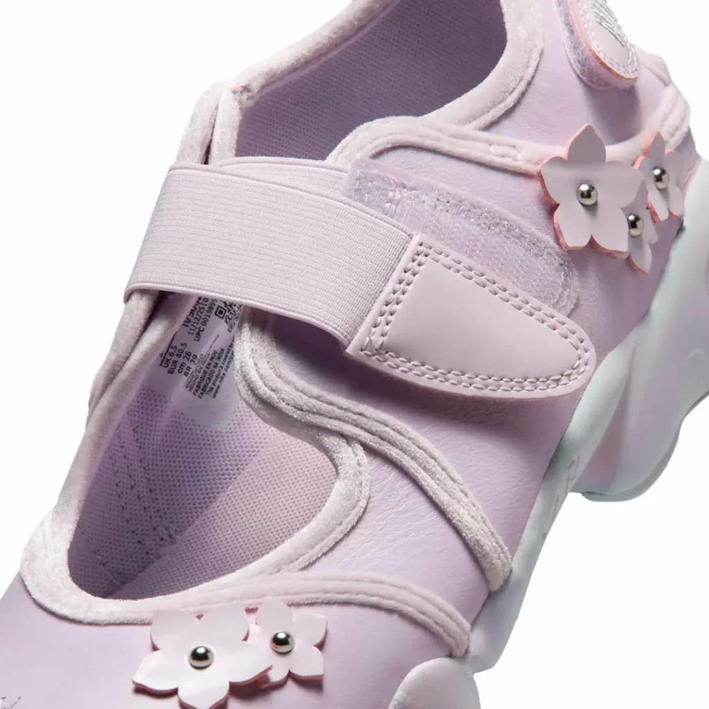 Close-up of the Air Rift upper featuring the hook-and-loop strap, soft suede trim, floral appliqués with metallic bead centers, and layered construction