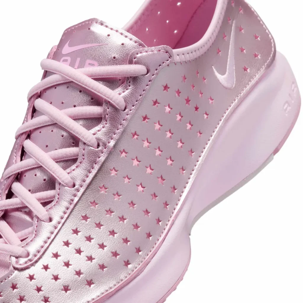 Close-up of the metallic pink upper featuring star-shaped perforations, tonal Swoosh, and soft pink lace