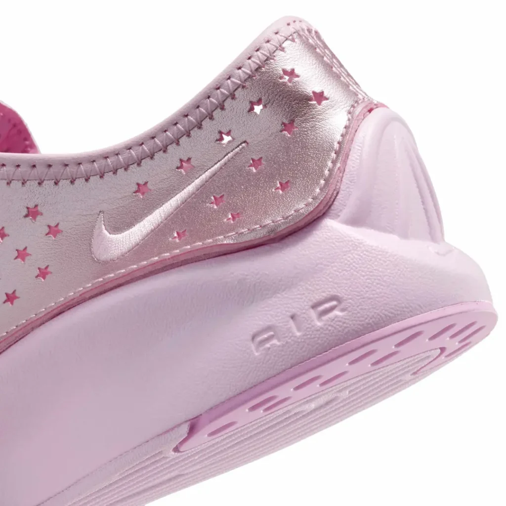 Close-up of the metallic pink upper featuring star-shaped perforations, tonal Swoosh, and soft pink lace
