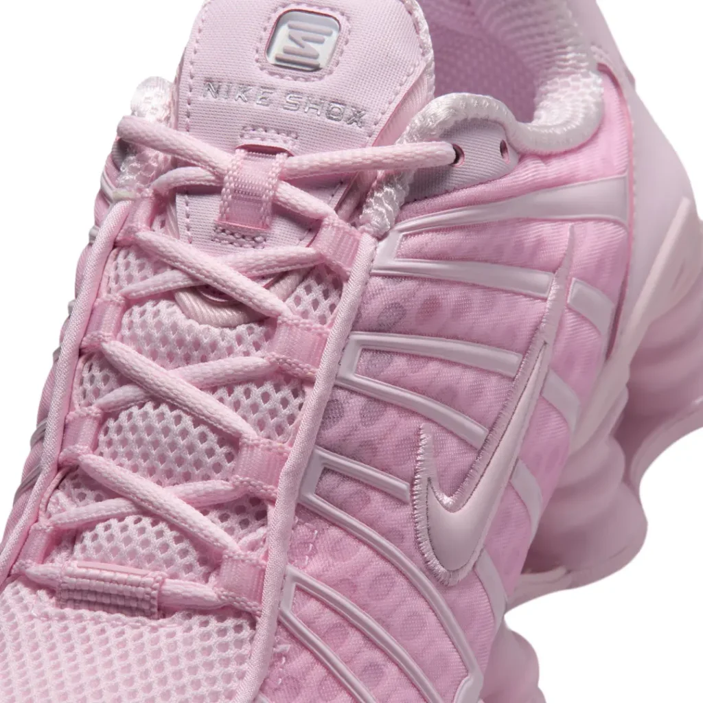 Close-up of the Nike Shox TL upper showing textured mesh panels, glossy TPU cage overlays, embroidered Swoosh, and Nike Shox tongue brand
