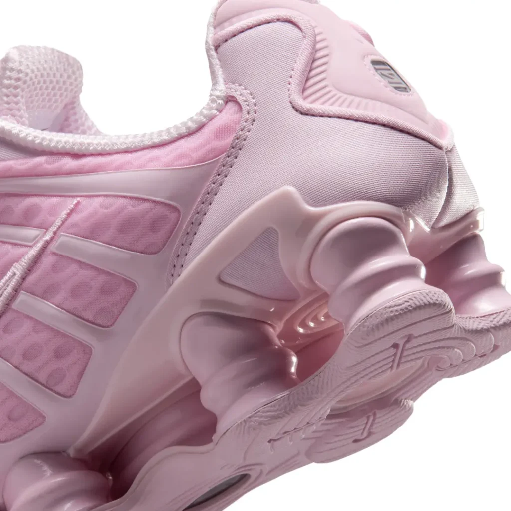 Detailed close-up of the rear Shox cushion system, molded heel support, and glossy pastel pink finish