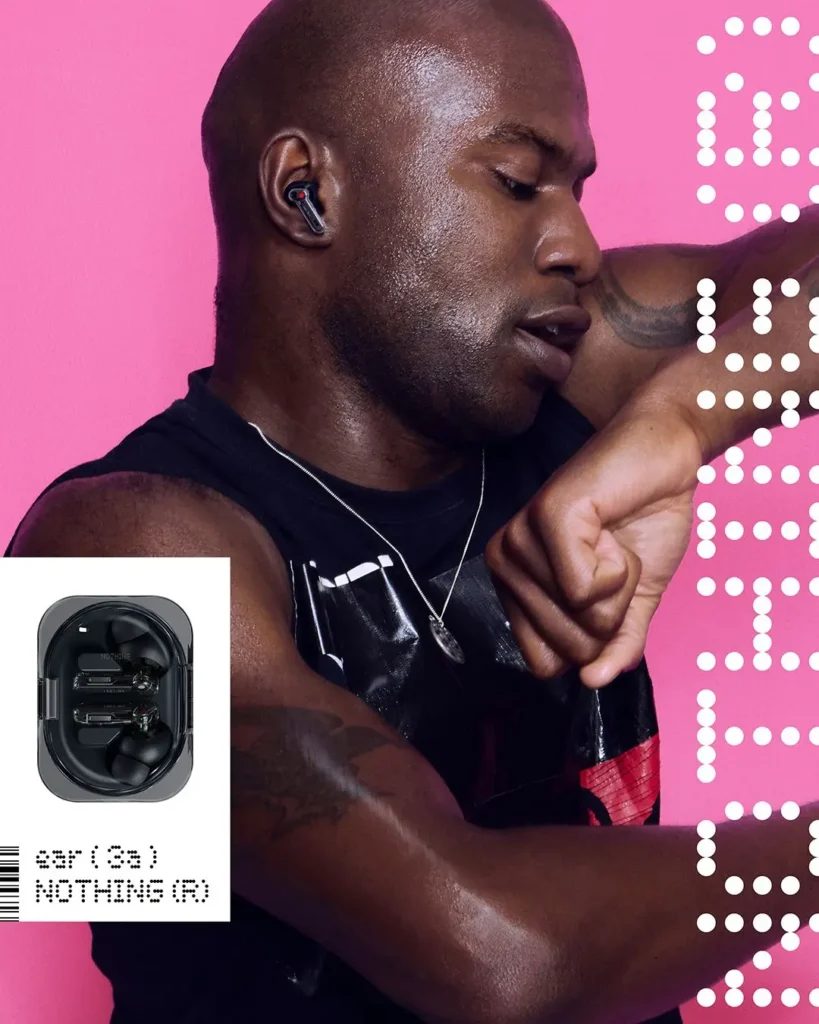 A model in a black sleeveless top wears the black Nothing Ear (3a) earbud against a vivid pink backdrop, accompanied by an inset showing the earbuds inside their transparent charging case