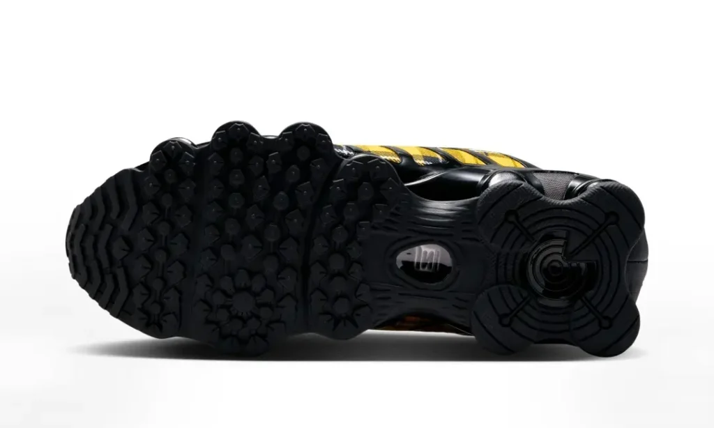Outsole view of the Nike Shox sneaker highlighting the black rubber traction pattern, segmented tread design, and view mid support window