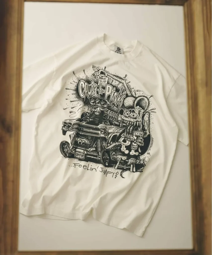 Off white short sleeve Tee on display, screen printed with a hot rod show, a "Pink Slip" tag, Rat Fink gripping a can, "Cruise for Pinks" lettering, and "...Feelin' Jumpy?" text below