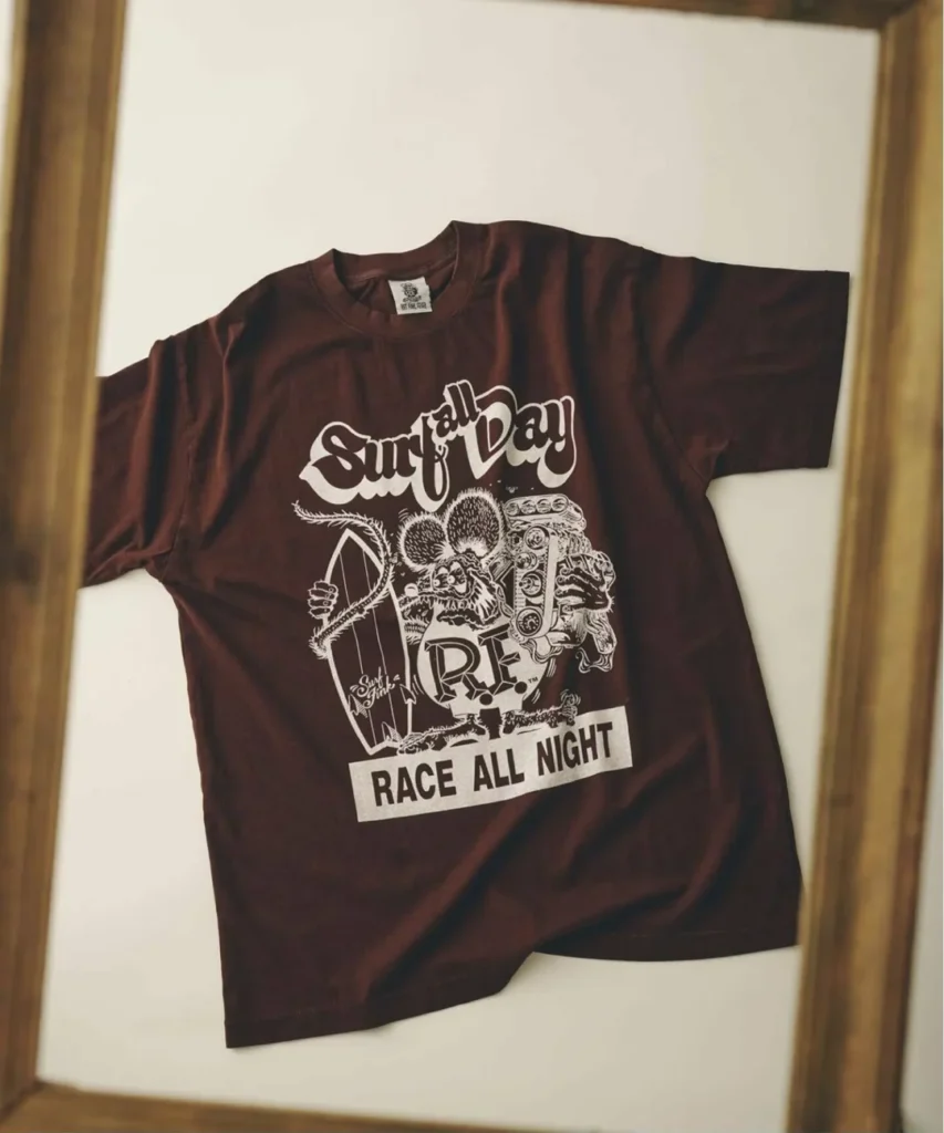 Maroon short sleeve Tee on display, screen printed with Rat Fink holding a surfboard beside an engine graphic, "Surf All Day" script text, an "R.F." emblem, and "Race All Night" letter