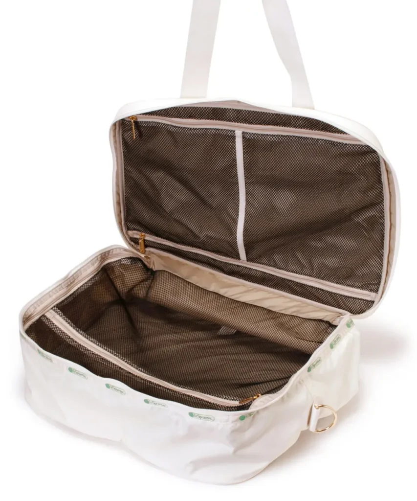 Open white LeSportsac travel duffel showcasing a roomy main compartment with zippered mesh divider and structured packing layout