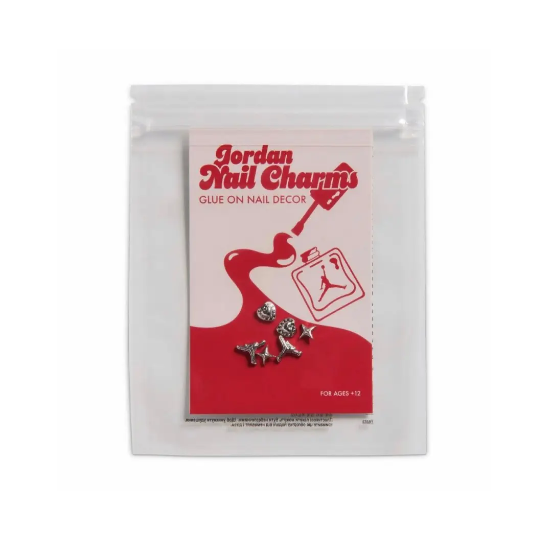 Jordan Nail Charms accessory kit in a clear resealable pouch, featuring metallic Jumpman-inspired nail charms and red-and-white packaging with nail polish-themed graphics.